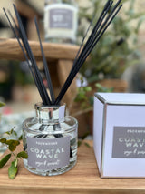 Diffuser with black sticks and 'Packhouse Coastal Wave' label on a wooden surface.