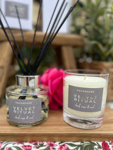 Packhouse Velvet Ritual candle and diffuser on a wooden surface with a blurred background